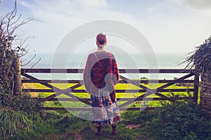 Young woman admiring sea view by rural fence