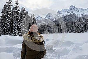 A young woman admiring the snowy views of Island Lake in Fernie, British Columbia, Canada.The majestic winter background is pretty