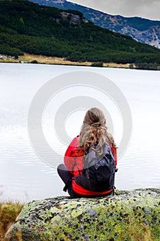 Young woman admiring the stillness of mountain lake