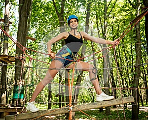 Young woman in adventure rope park. Climbing Equipment.