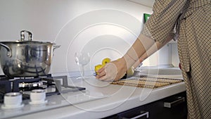 A young woman against the background of a modern kitchen set with a plate of lemons. A girl in the kitchen holds a plate