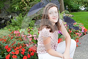 young woman against summer flowers in garden park summer