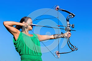 Young woman aiming arrow of compound bow