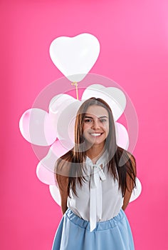 Young woman with air balloons on pink. Celebration of Saint Valentine`s Day