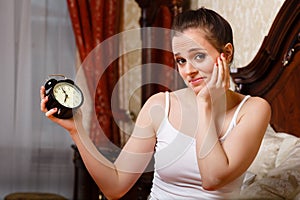 Young woman with alarm clock.