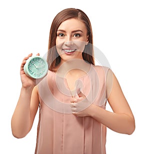 Young woman with alarm clock on white background. Time management concept