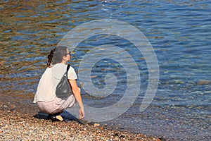 Young woman alone on a Mediterranean beach, France