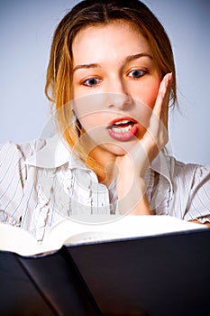 Young woman amazed by what she is reading