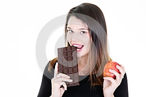 Young woman with apple fruit and chocolate being tempted