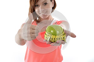 Young woman with apple and measure tape