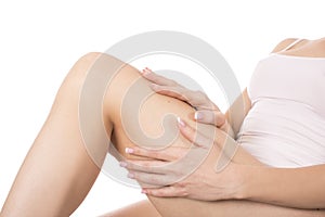 Young woman apply body lotion on her legs. Skin care and health concept.