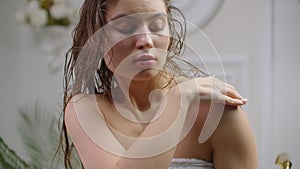 Young woman applying body lotion at morning. Close up of woman body care at home. Portrait of woman applying moisturizer