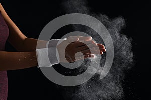 Young woman applying chalk powder on hands