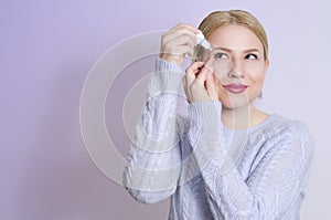Young woman applying eye drops