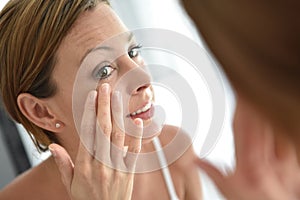 Young woman applying facial cream