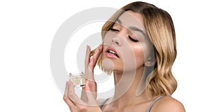 Young woman applying facial gel, peeling or mask on her face