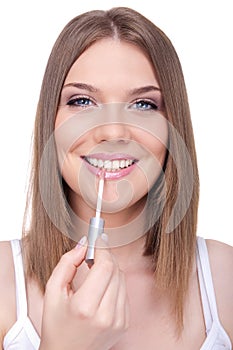 Young woman applying lip gloss