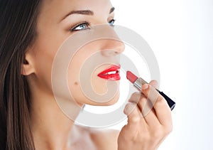 Young woman applying lipstick