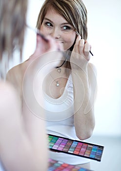 Young woman applying mascara