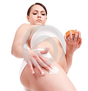 Young woman applying moisturizer cream.