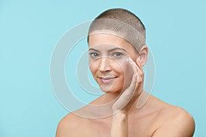 Young woman applying moisturizer cream. Beauty and Skincare concept.