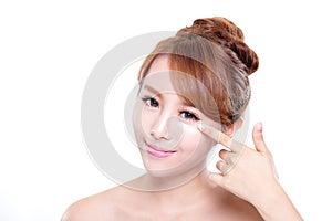 Young woman applying moisturizer cream on face