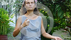 Young woman applying mosquito repellent to her skin, summer