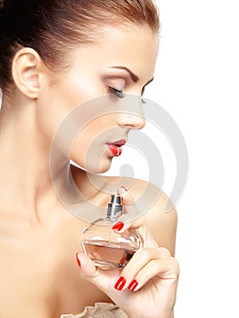 Young woman applying perfume on herself isolated on white background photo
