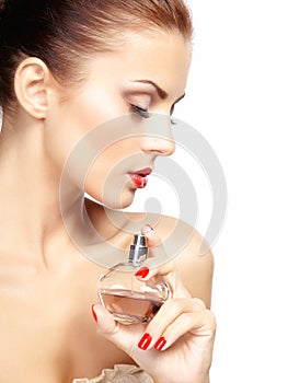 Young woman applying perfume on herself isolated on white background