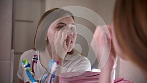 A young woman applying shadows on the brows