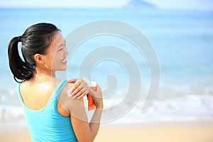 Young woman applying sun block cream body