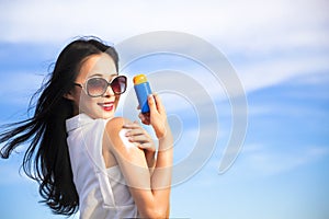 Young woman applying sun protection lotion