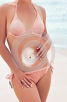 Young woman applying sunscreen lotion. A Female  smear  sun cream on beach. Sun protection