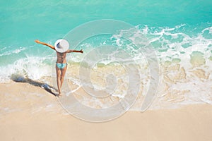 Young woman with arms apart on sand beach photo