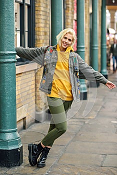 Young woman arms raised enjoying in urban background