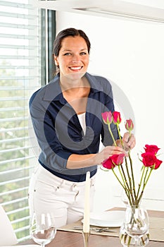 Young woman arranging flowers dinner table