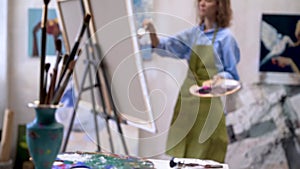 Young woman artist painting at art studio