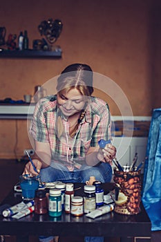 Young woman artist painting at home creative.