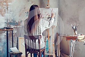 Young woman artist painting at home creative person