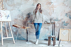 Young woman artist painting at home creative standing looking camera