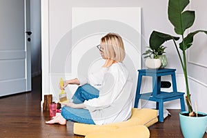 Young woman artist is painting at home in a creative studio setting.