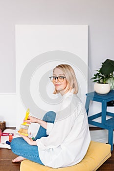 Young woman artist is painting at home in a creative studio setting.