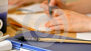 Young woman artist painting at home studio creative tools close-up