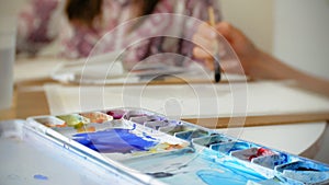 Young woman artist painting at home studio creative tools close-up