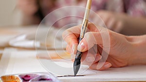 Young woman artist painting at home studio creative tools close-up