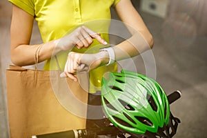 Young woman as a courier delivering package using gadgets