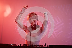 Young woman as female DJ at disco party in neon light