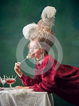 Young woman as Marie Antoinette on dark background. Retro style, comparison of eras concept.