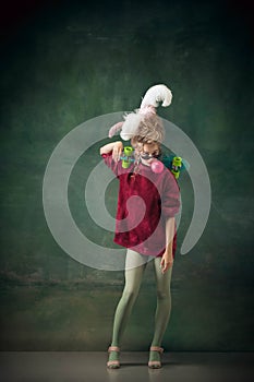 Young woman as Marie Antoinette on dark background. Retro style, comparison of eras concept.