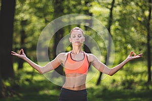 Young woman in asana is enjoying connection with nature